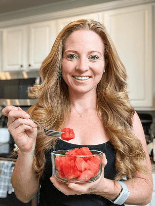 Kristie with a bowl of watermelon and a piece on her fork